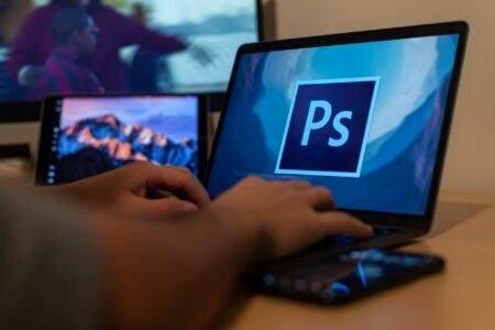 A Person Is Using A Laptop With The Adobe Logo On It To Remove Watermarks.