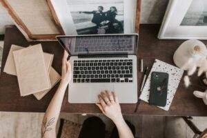 A woman optimizing SEO content using a laptop on a wooden desk.